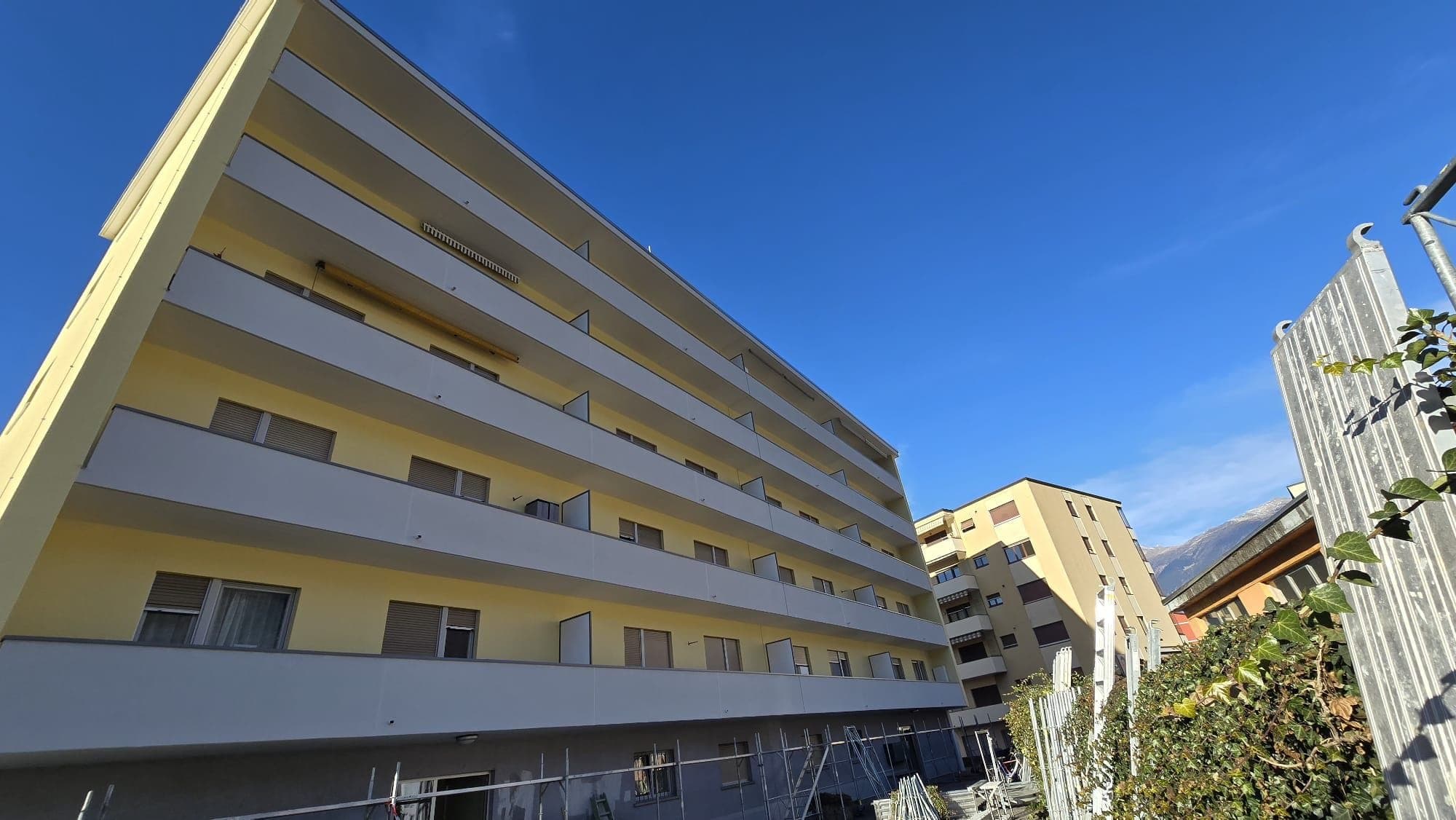 Cantiere cappotto termico con ponteggi a Minusio