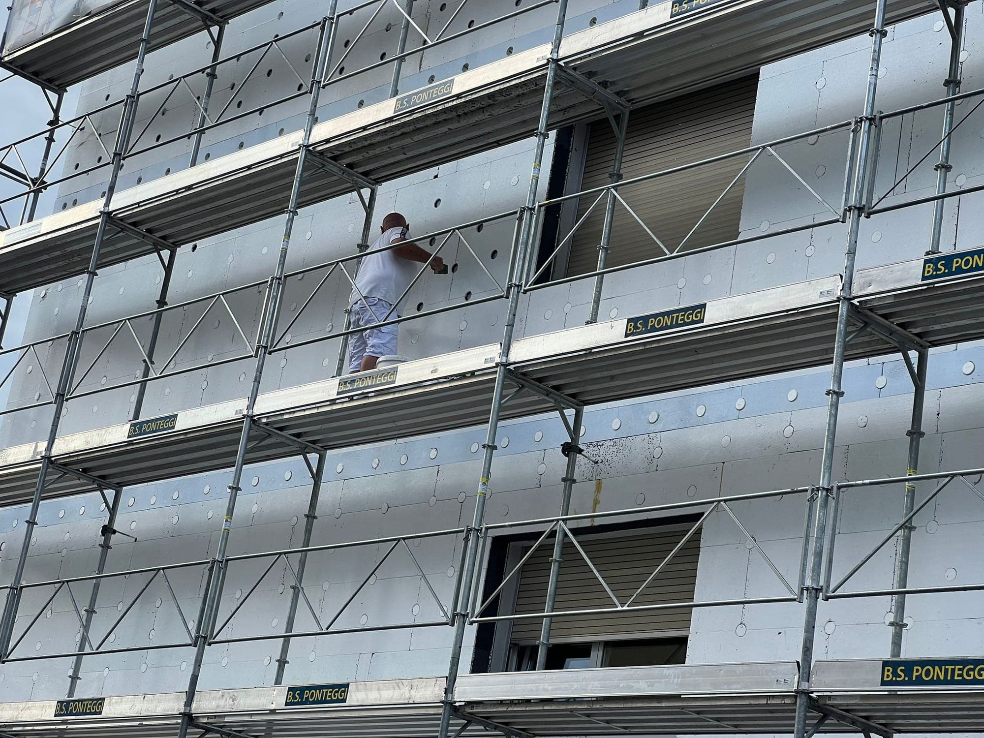 Pittore Libera Pittura al lavoro su cappotto termico